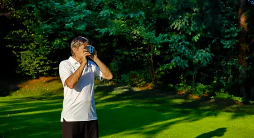a man using a rangefinder on the golf course