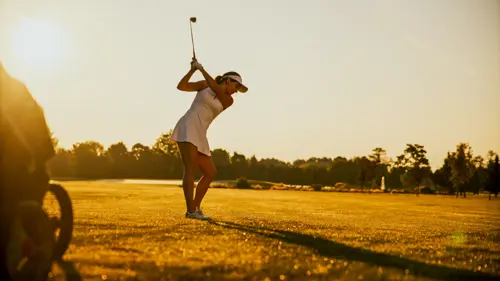 Woman hitting a fairway wood on the golf course